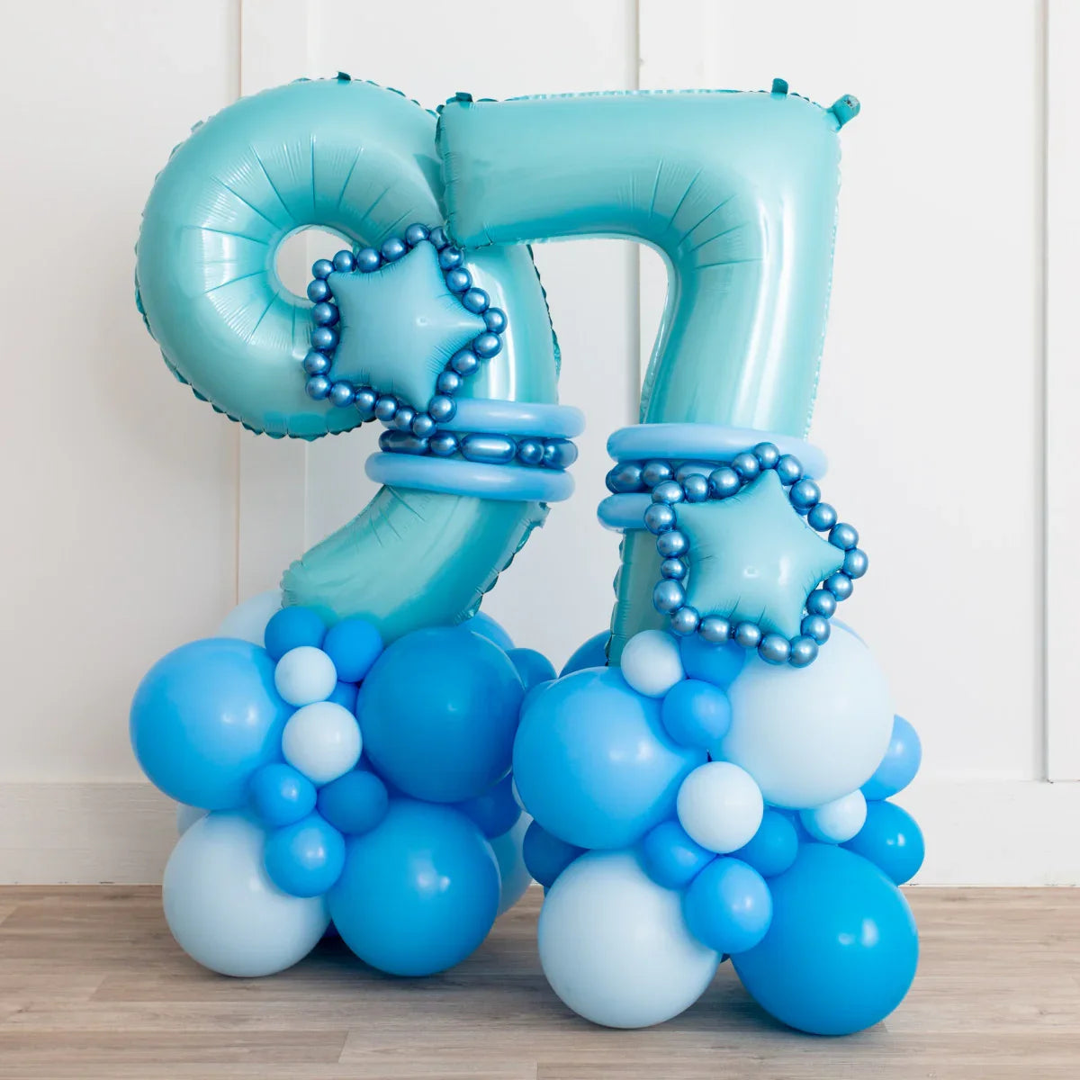 Blue balloon number 97 decorated with star-shaped and round balloons on wooden floor