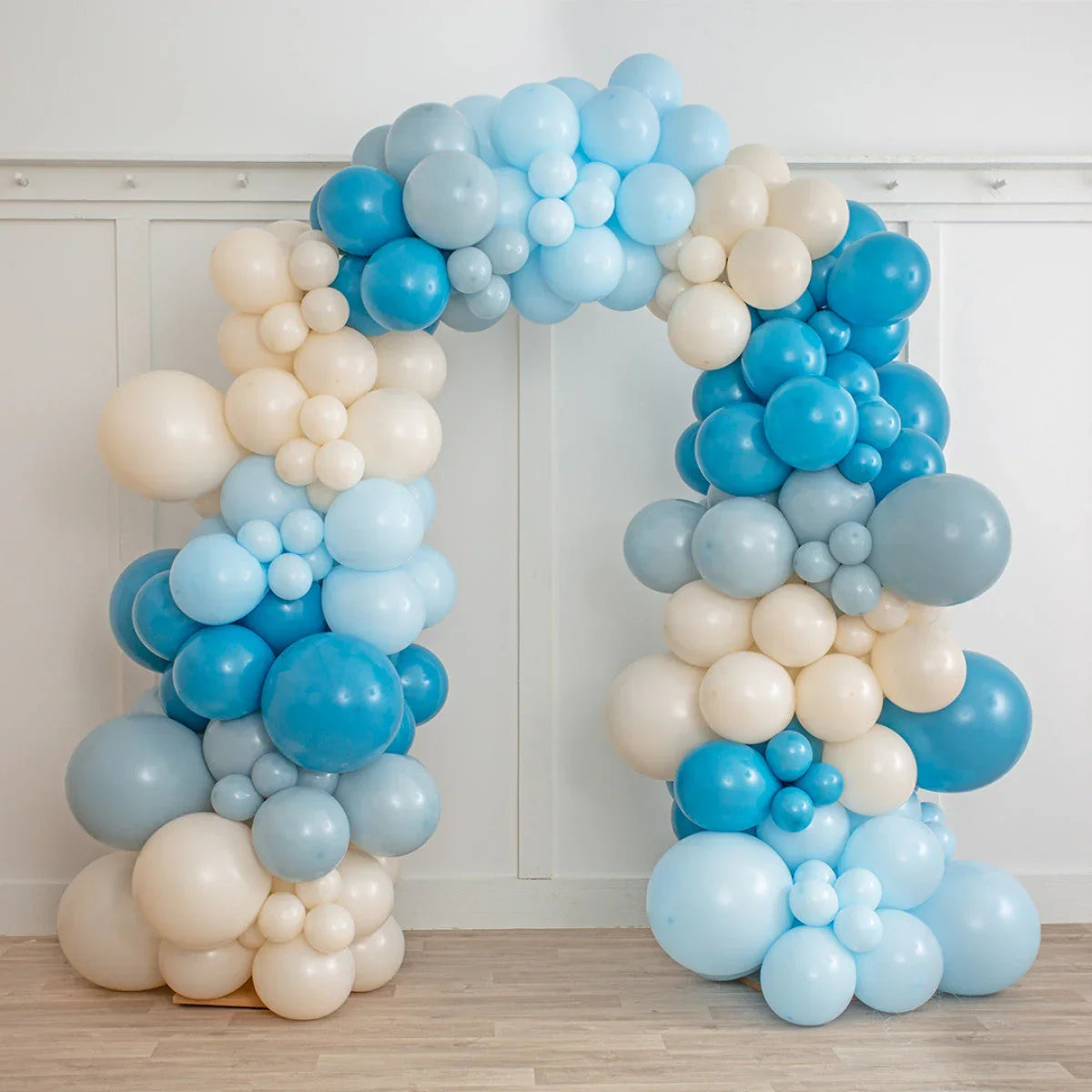 Balloon arch with ocean and beige bubbles in various sizes against white wall