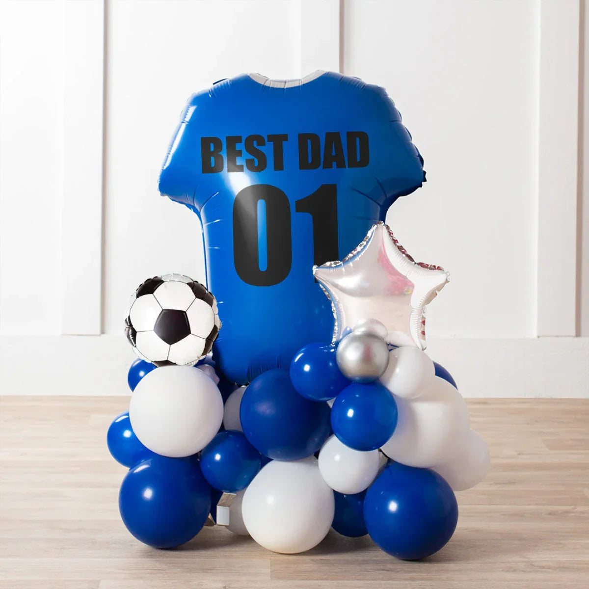 Blue football shirt balloon with text Best Dad 01 surrounded by blue, white, silver balloons and a soccer ball balloon