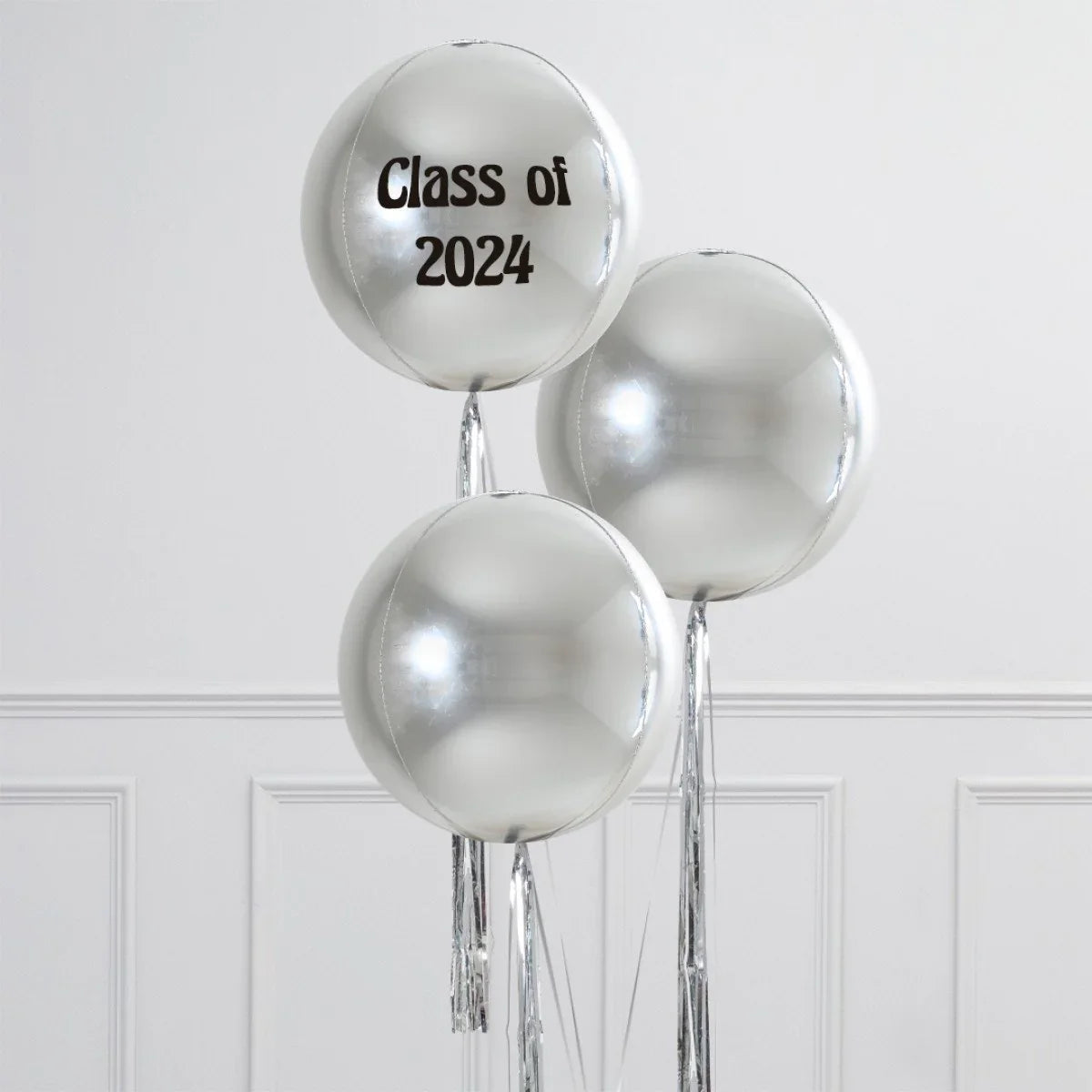 Silver orb helium balloons with one personalized balloon reading 'Class of 2024' against white wall