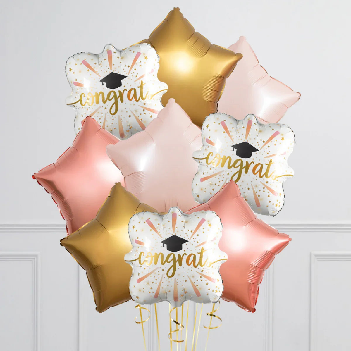 Rose gold, gold, and white 'congrats' graduation foil balloons with star shapes and cap design