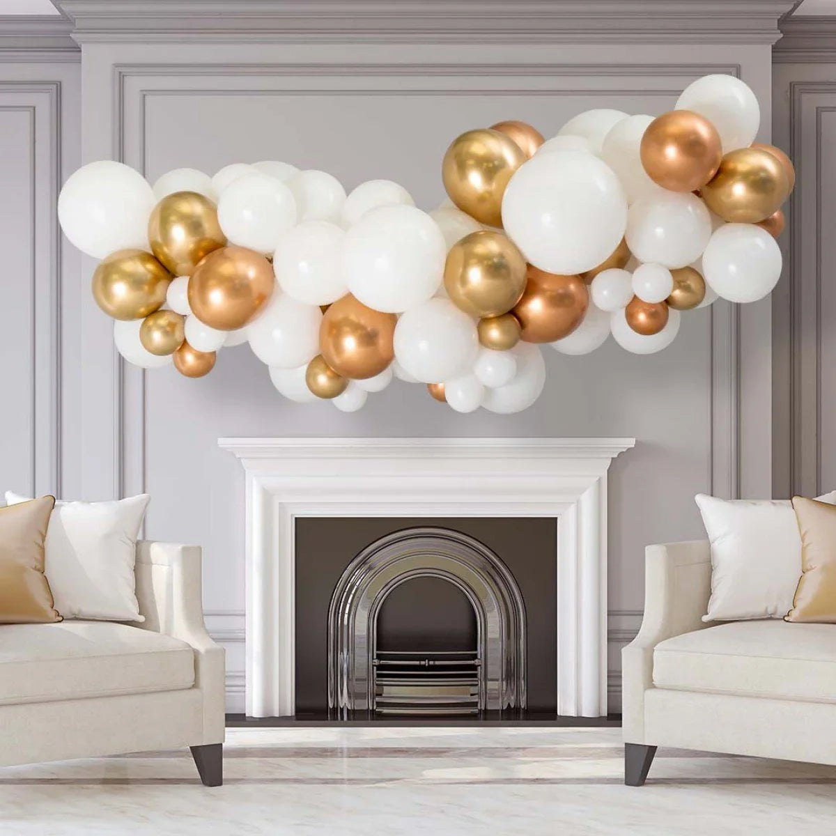 Copper and chrome balloon garland decoration above white fireplace in elegant living room