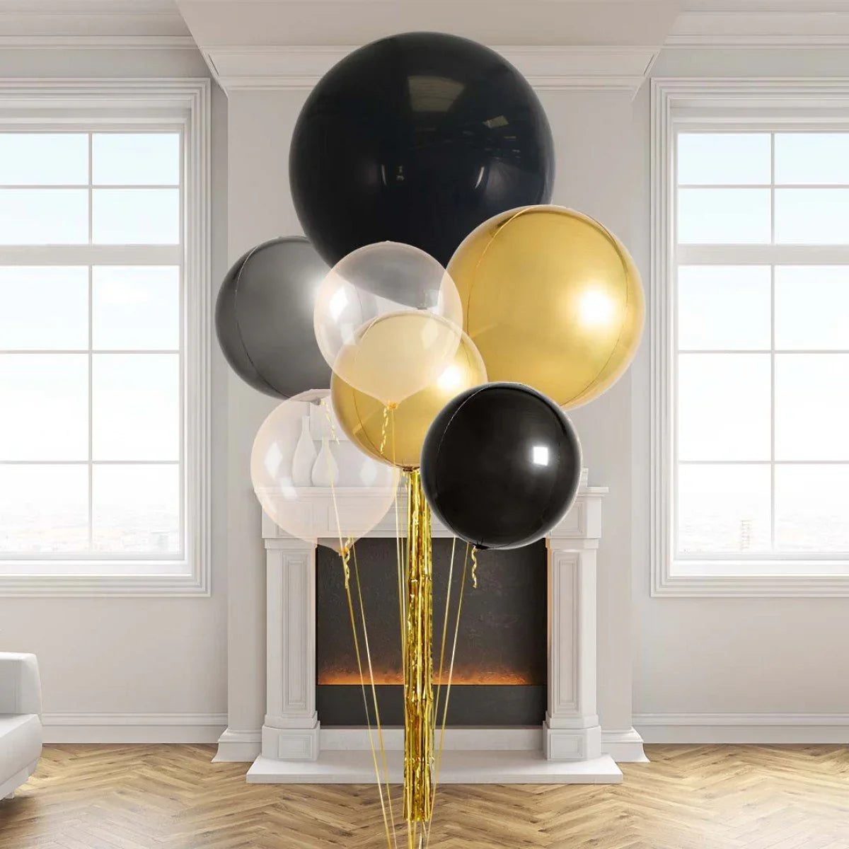 Giant black, gold, and clear helium balloons bunch with gold tassels in a bright modern living room