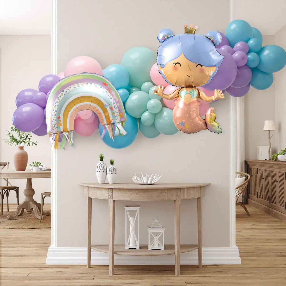 Pastel balloon garland with mermaid and rainbow foil balloons decorating a modern living room
