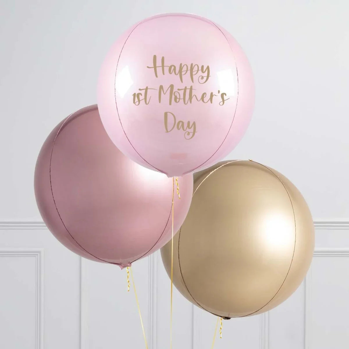 Three large round balloons in pink, rose gold, and gold, with the pink balloon reading 'Happy 1st Mother's Day'