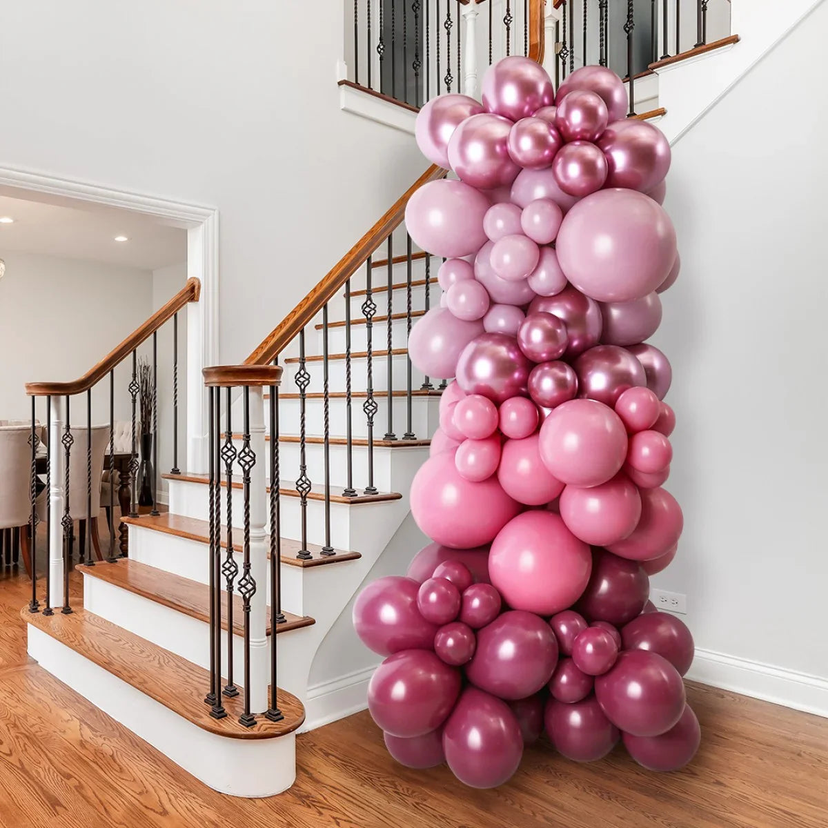 Pink and mauve balloon pillar decoration next to wooden staircase in modern home interior