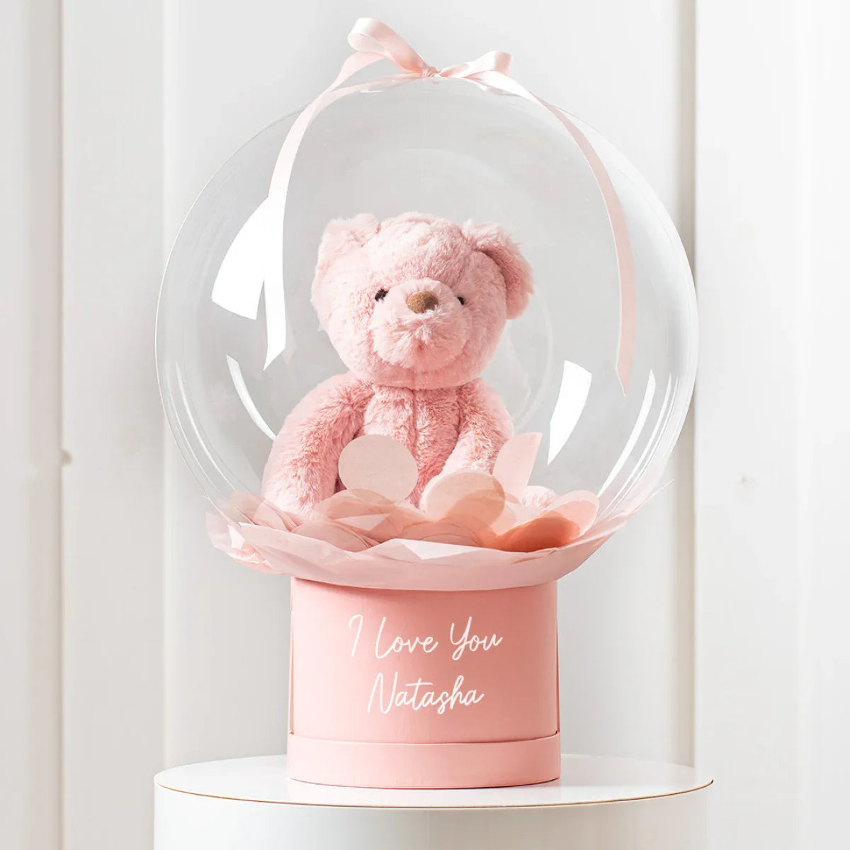 Personalised pink teddy bear inside clear balloon with pink confetti on pink base reading I love you Natasha