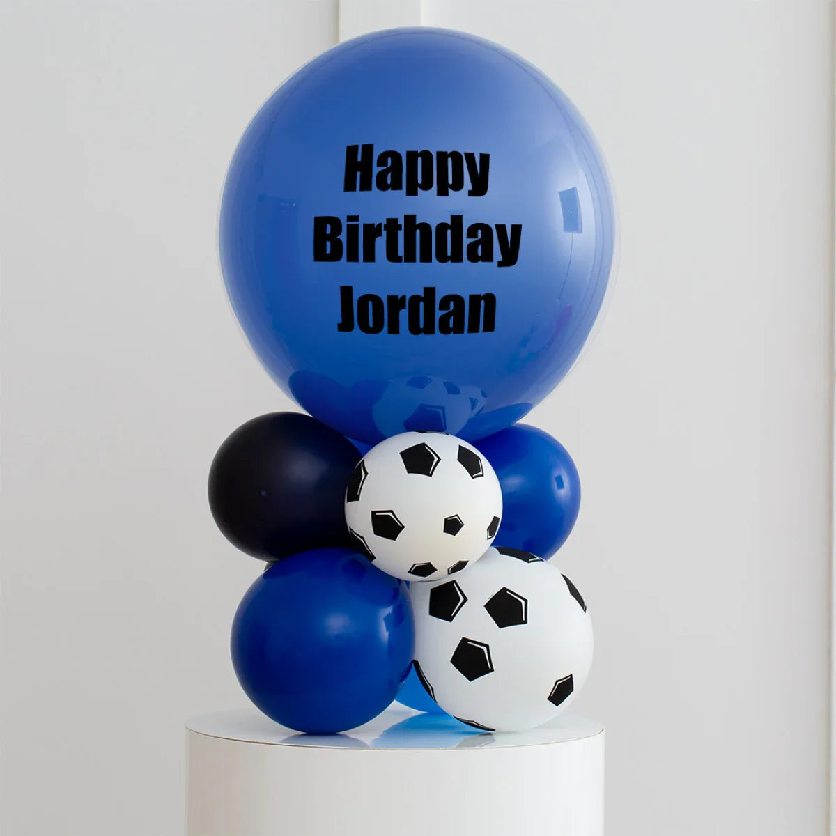 Personalised blue and black soccer-themed balloon stack with Happy Birthday Jordan message
