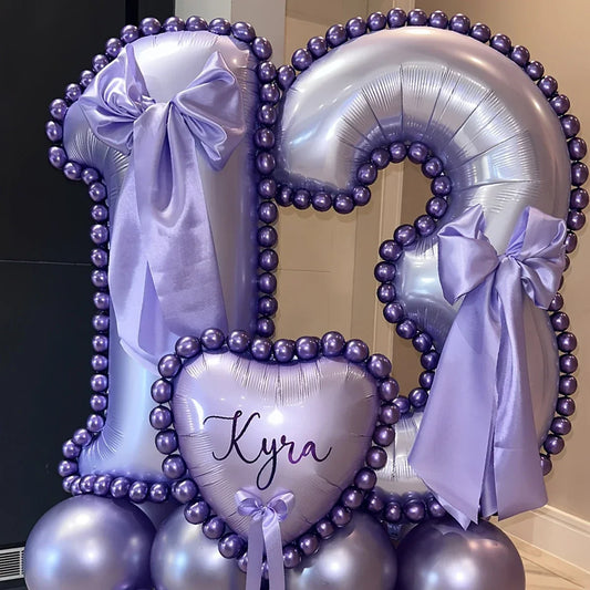 Purple and silver number 13 birthday balloon display with bows and heart-shaped balloon reading Kyra