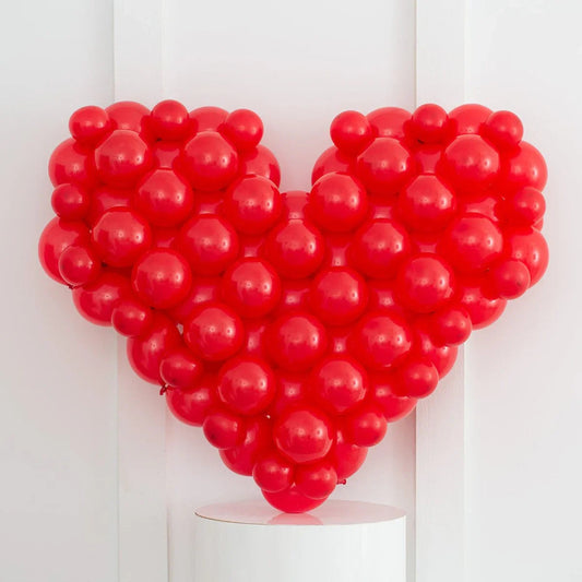 Red mosaic heart made of clustered red balloons against a white background