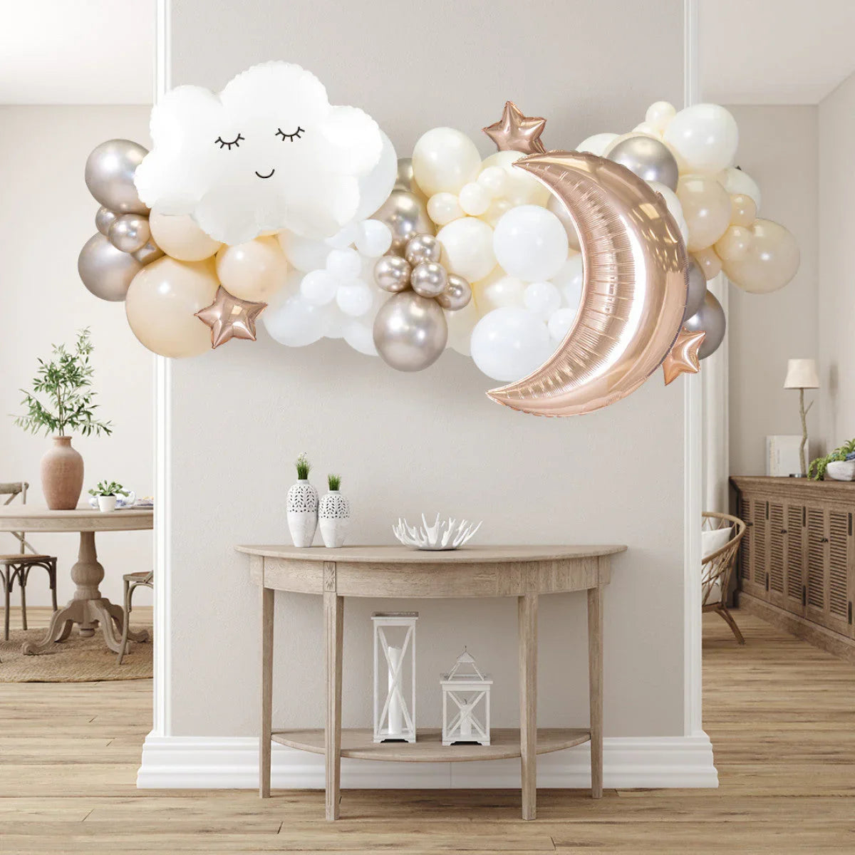 Neutral-toned balloon garland with cloud, crescent moon, and star balloons above wooden table in modern living room