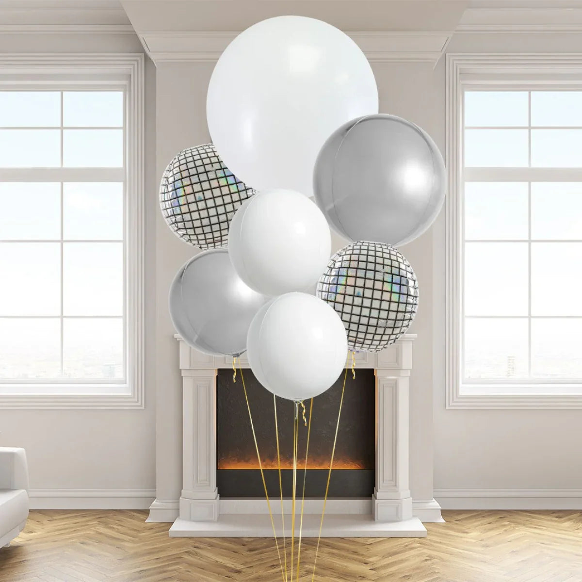 Cluster of white, silver, and disco ball patterned balloons in a modern room with fireplace and large windows