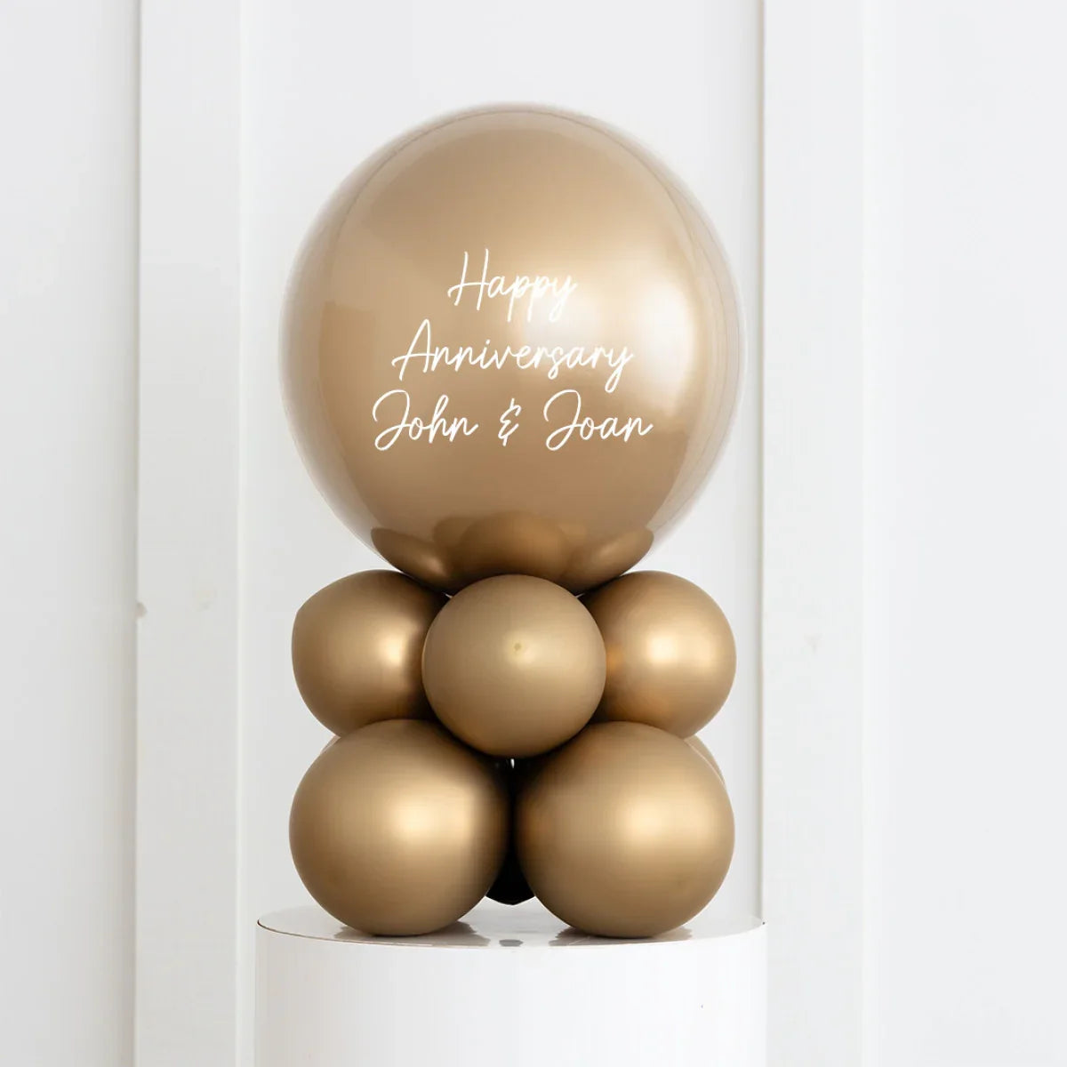 Gold chrome anniversary balloon centerpiece with Happy Anniversary John & Joan text