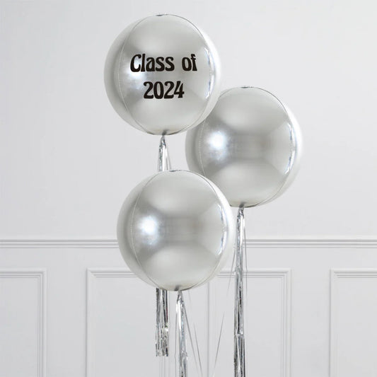 Silver helium balloons with one reading 'Class of 2024' against white wall paneling