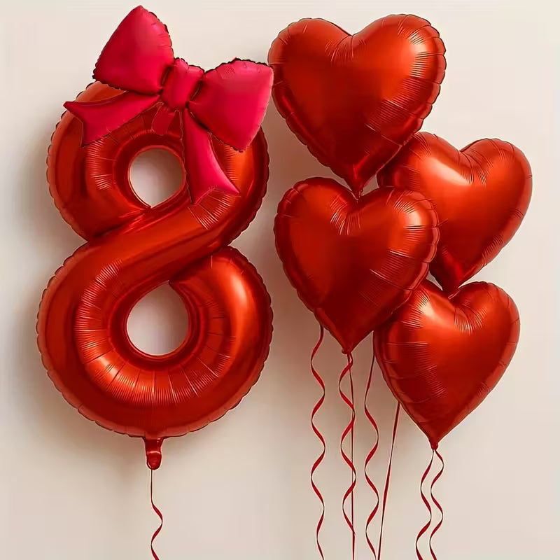 Red foil balloons including number 8 with pink bow and five heart-shaped balloons for birthday party decoration