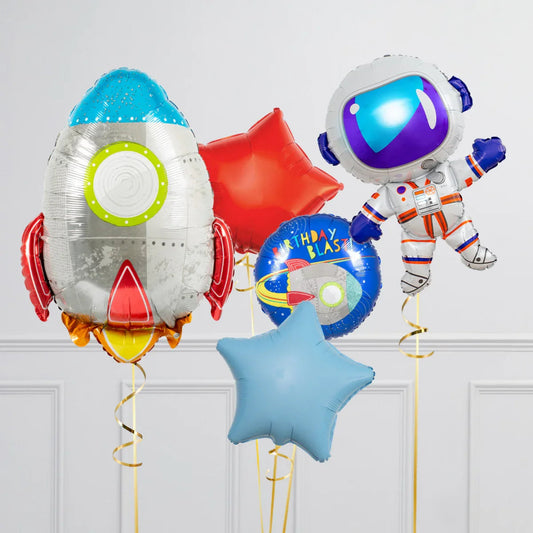 Space-themed foil balloons including a rocket, astronaut, stars, and birthday blast in a decorated room