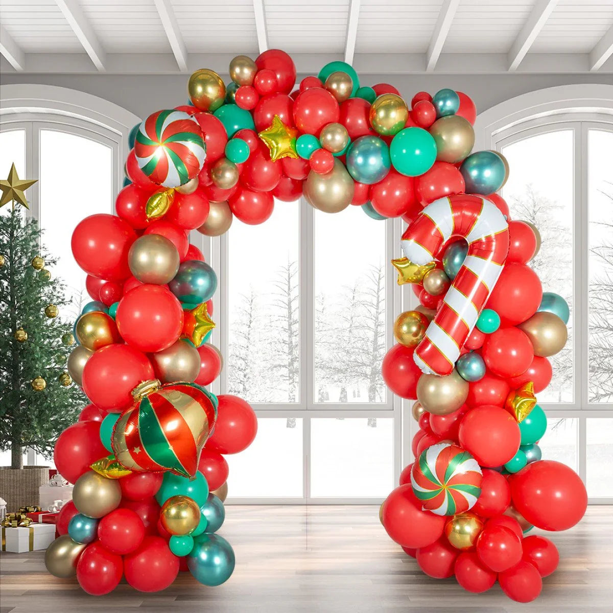Christmas balloon arch with red, green, gold balloons and festive ornaments in snowy room
