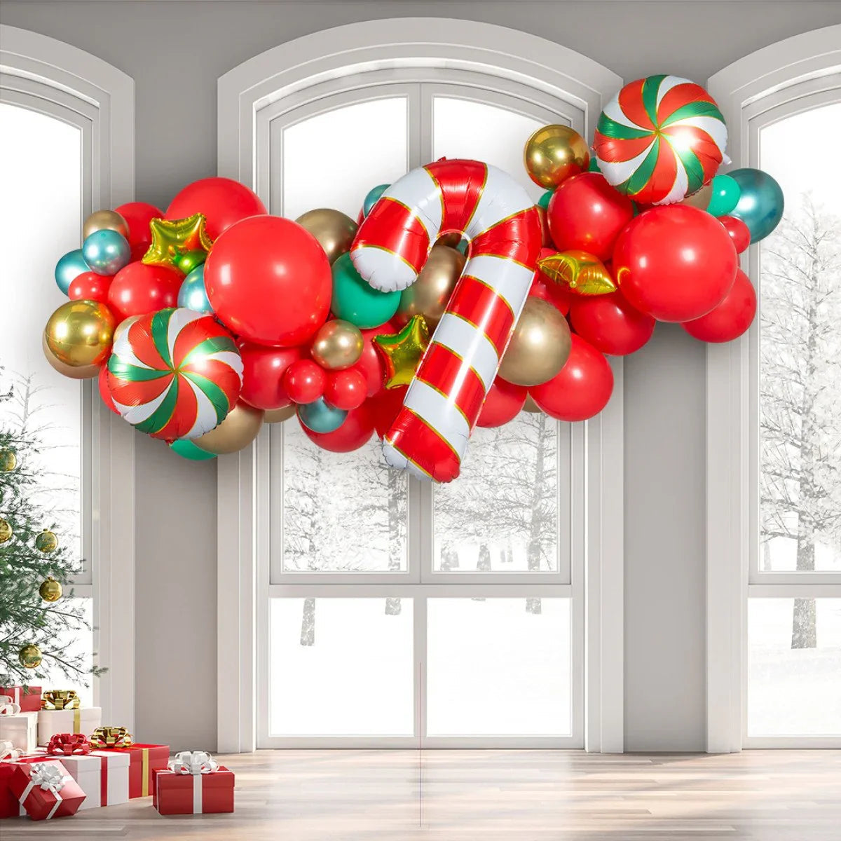 Festive balloon garland with red, gold, green balloons and candy cane foil balloon near large windows