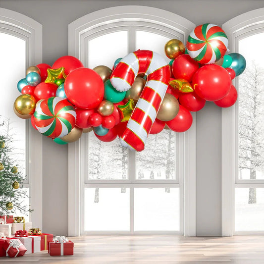 Festive balloon garland with red, gold, green balloons and candy cane foil balloon near large windows