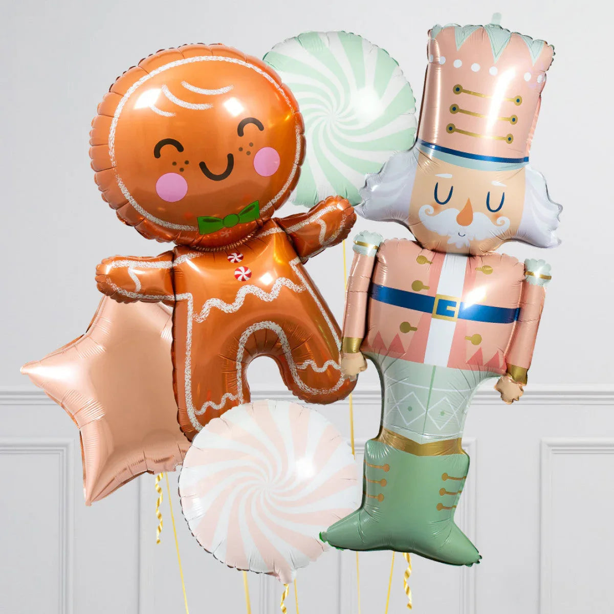 Festive helium balloons featuring a smiling gingerbread man, nutcracker soldier, star, and peppermint swirls
