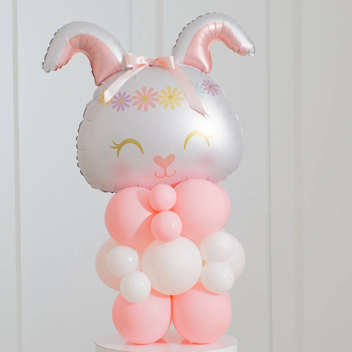 Pink and white balloon bunny with floral crown and bow, Easter-themed party decoration