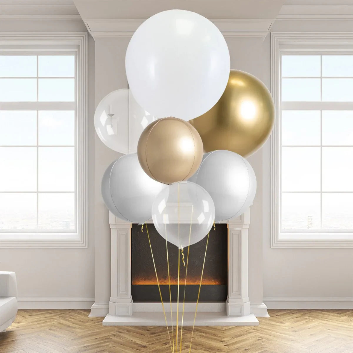 Cluster of large gold, white, and clear helium balloons in an elegant living room with bright windows and a modern fireplace