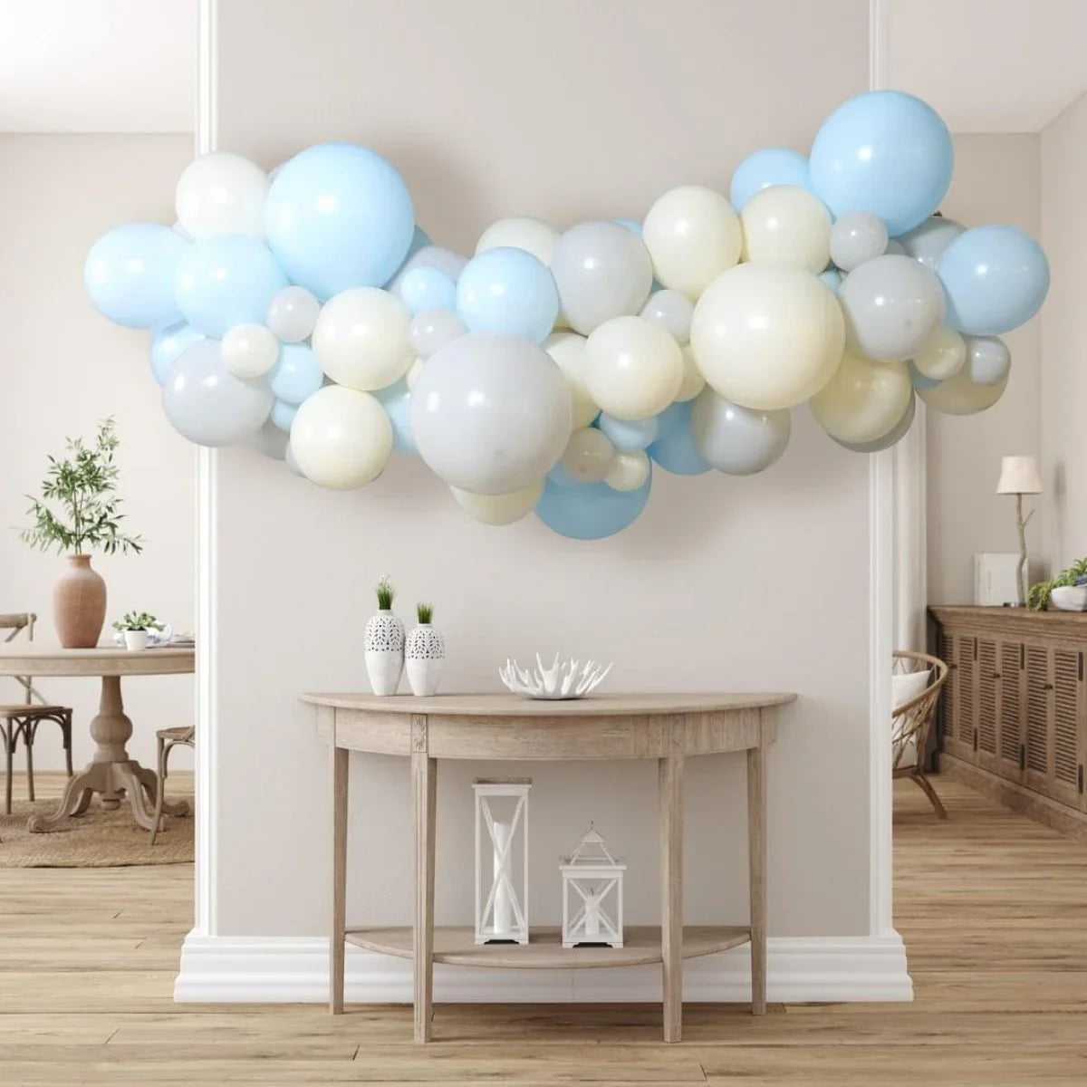 Blue, white, and cream balloon garland hanging above wooden console table in modern living room
