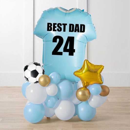 Personalised pale blue football shirt balloon with text Best Dad 24, surrounded by white, blue, gold balloons and a soccer ball