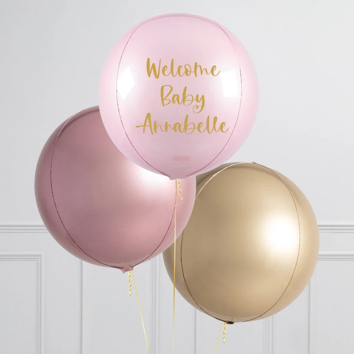 Personalized pink balloon with gold text Welcome Baby Annabelle, alongside rose gold and gold balloons
