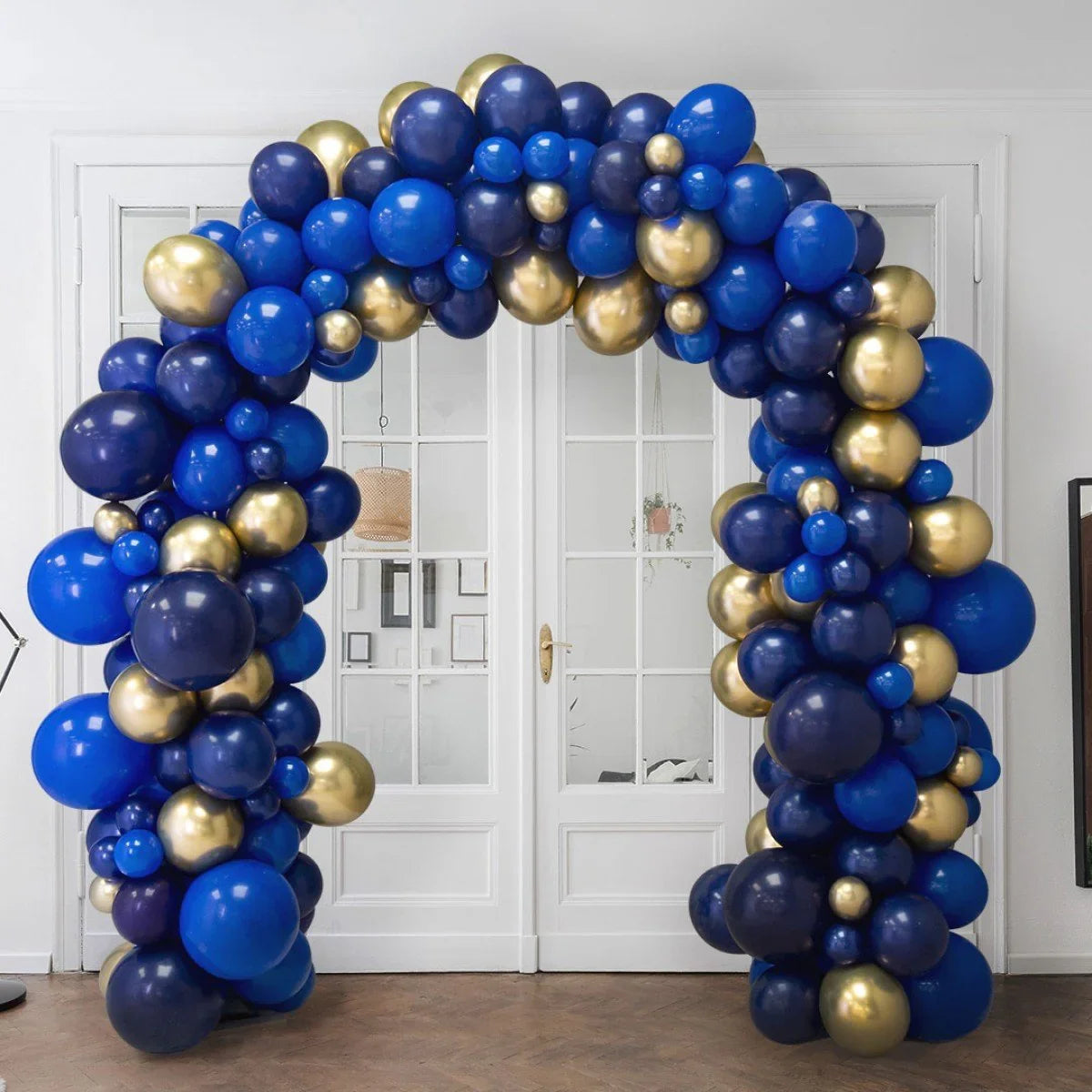 Sapphire blue and gold balloon arch in front of white double glass doors indoors