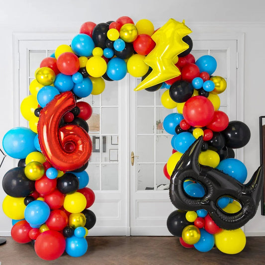 Colorful balloon arch with red number 6, yellow lightning bolt, and black superhero mask balloons