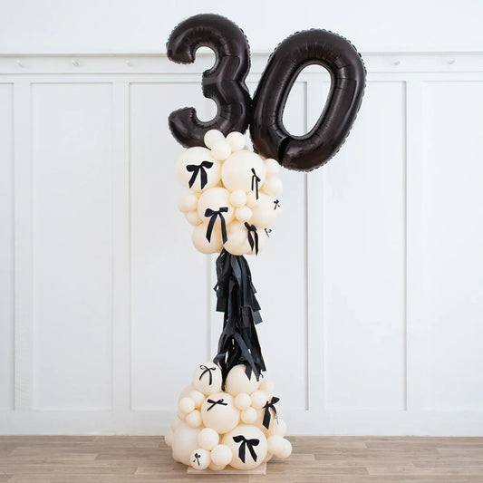 Elegant black and ivory balloon party pillar with black number 30 balloons and decorative bows