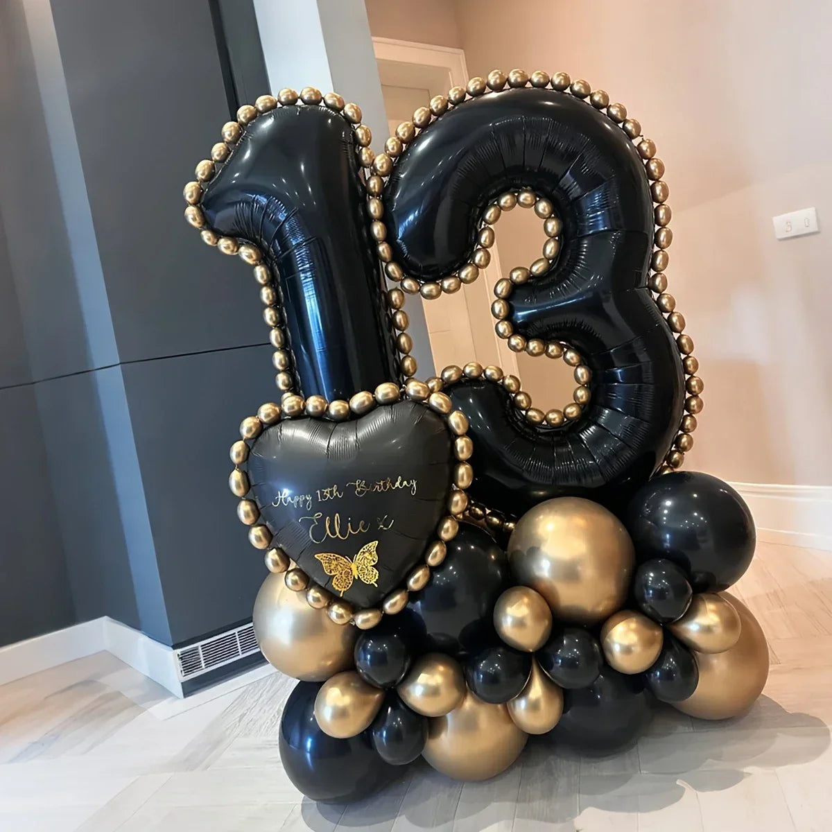 Black and gold balloon arrangement with number 13 and heart balloon celebrating 13th birthday
