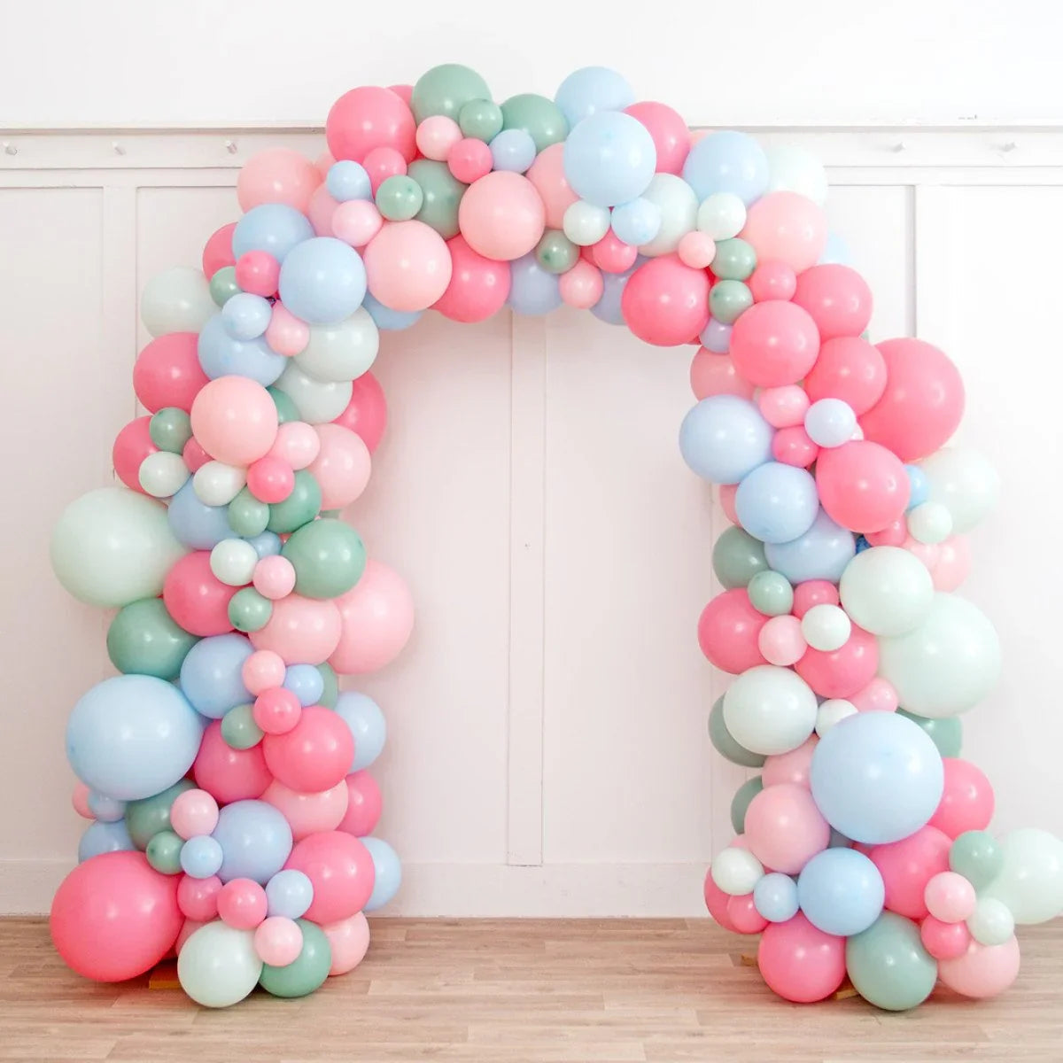 Colorful balloon arch with pastel pink, blue, green, and white balloons for party decoration
