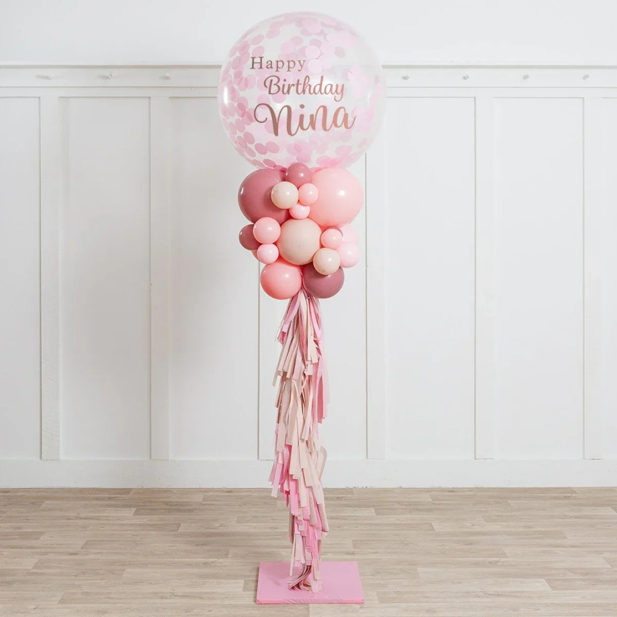 Pink birthday balloon pillar decoration with confetti balloon saying Happy Birthday Nina