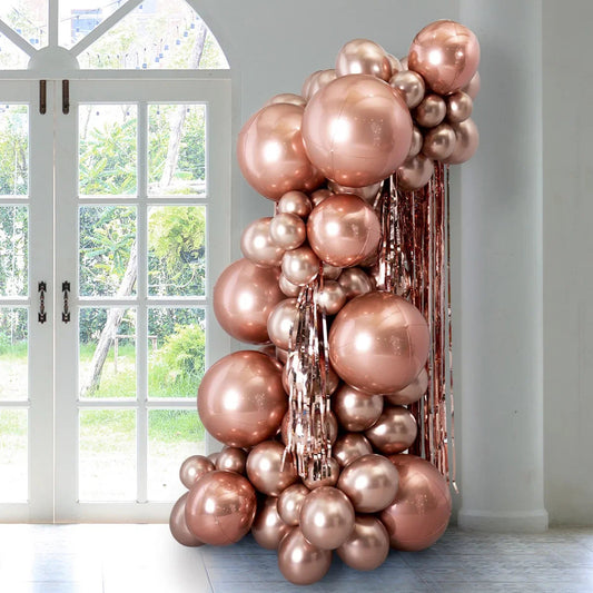 rose gold balloon pillar decoration with metallic tassels indoor near white window