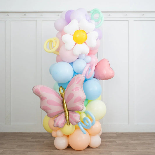 Pastel rainbow balloon pillar with white daisy, pink heart, and butterfly foil balloons