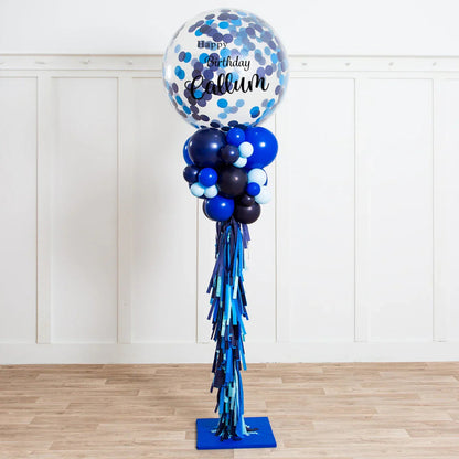 Tall blue and black birthday balloon pillar with confetti balloon saying Happy Birthday Callum indoors