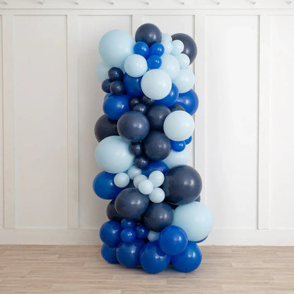 vertical balloon pillar in dark blue, royal blue, and light blue shades against white wall