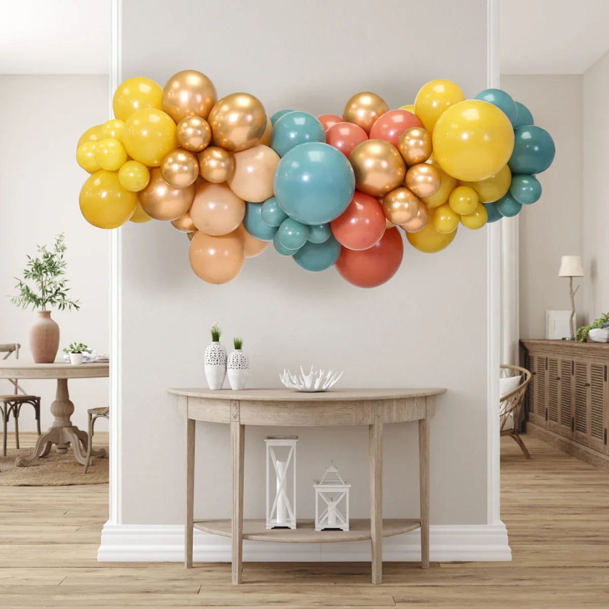 Colorful inflated balloon garland in desert sunset tones hanging above wooden console table in modern living room