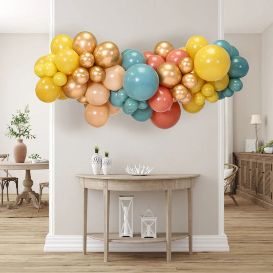 Colorful inflated balloon garland in desert sunset tones hanging above wooden console table in modern living room