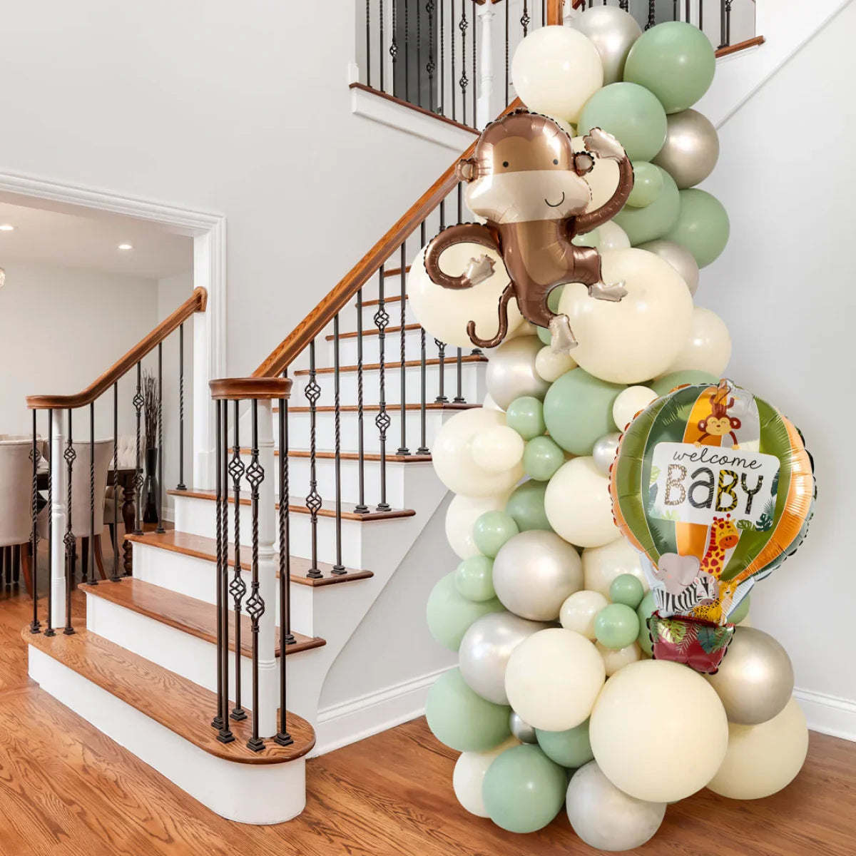 Eucalyptus balloon pillar with monkey and hot air balloon welcome baby foil balloons by wooden staircase