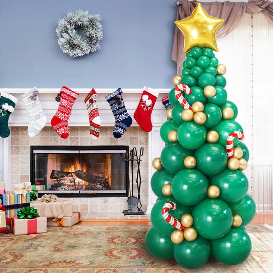 Festive green balloon Christmas tree with gold balloons, red candy canes, and a gold star topper near a cozy fireplace with stockings and wrapped gifts