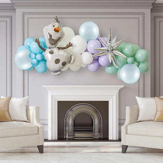 Colorful balloon garland with Olaf foil balloon and star decoration above modern white fireplace