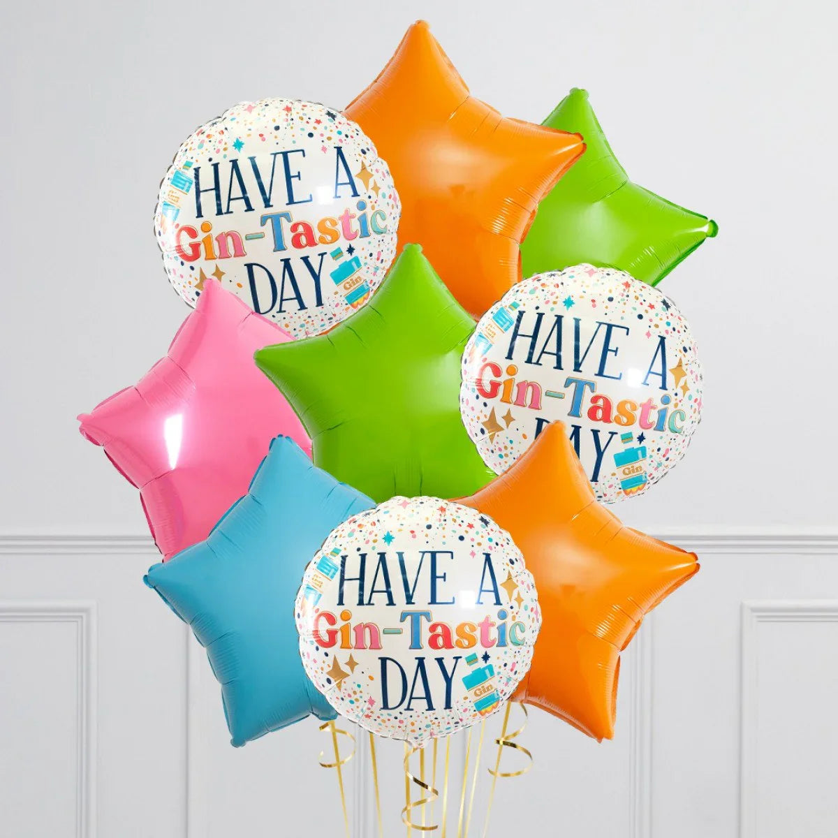 Colorful foil balloon bunch with star shapes and round balloons saying 'Have a Gin-Tastic Day', party decoration