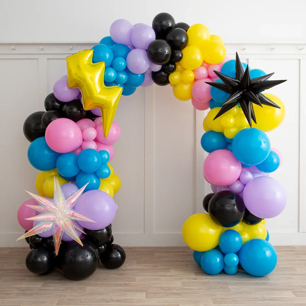 Colorful balloon arch with yellow, pink, blue, black, purple balloons and star-shaped foil balloons