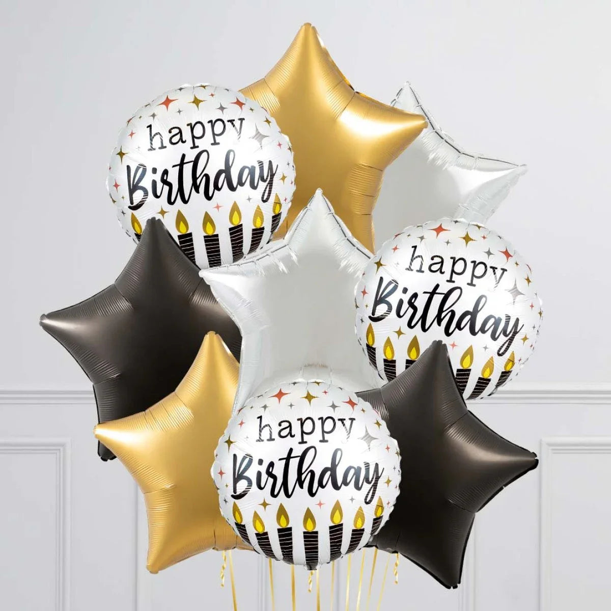 Happy birthday foil balloons with candles and star shaped balloons in gold, black, and silver