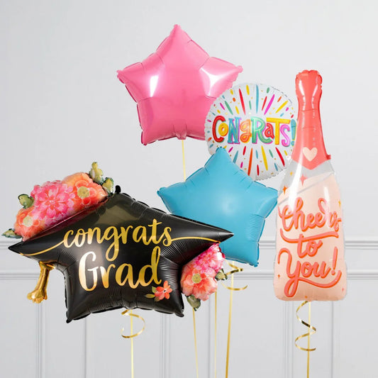 Colorful congratulation balloons including a black grad cap, pink and blue stars, confetti circle, and champagne bottle