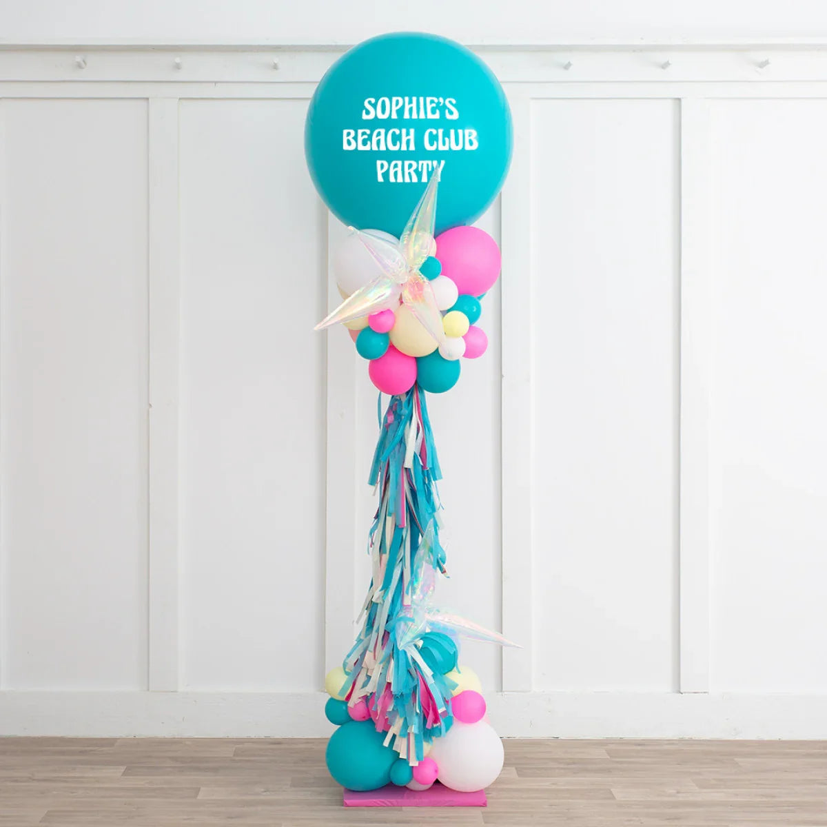 Tall balloon pillar decoration with teal, pink, white balloons and iridescent star shapes for Sophie's Beach Club Party