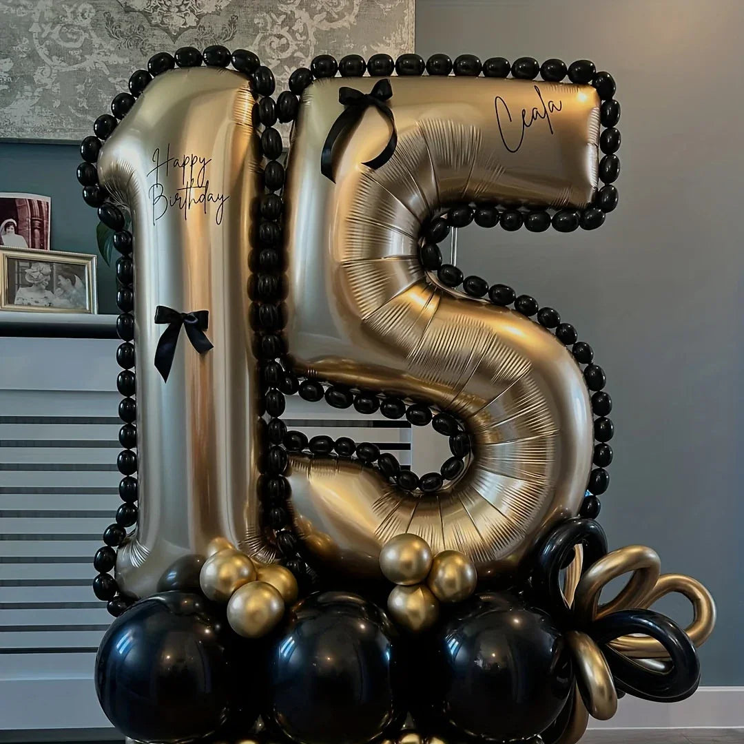 Gold and black balloon arrangement in numbers 1 and 5 for 15th birthday celebration with black bows